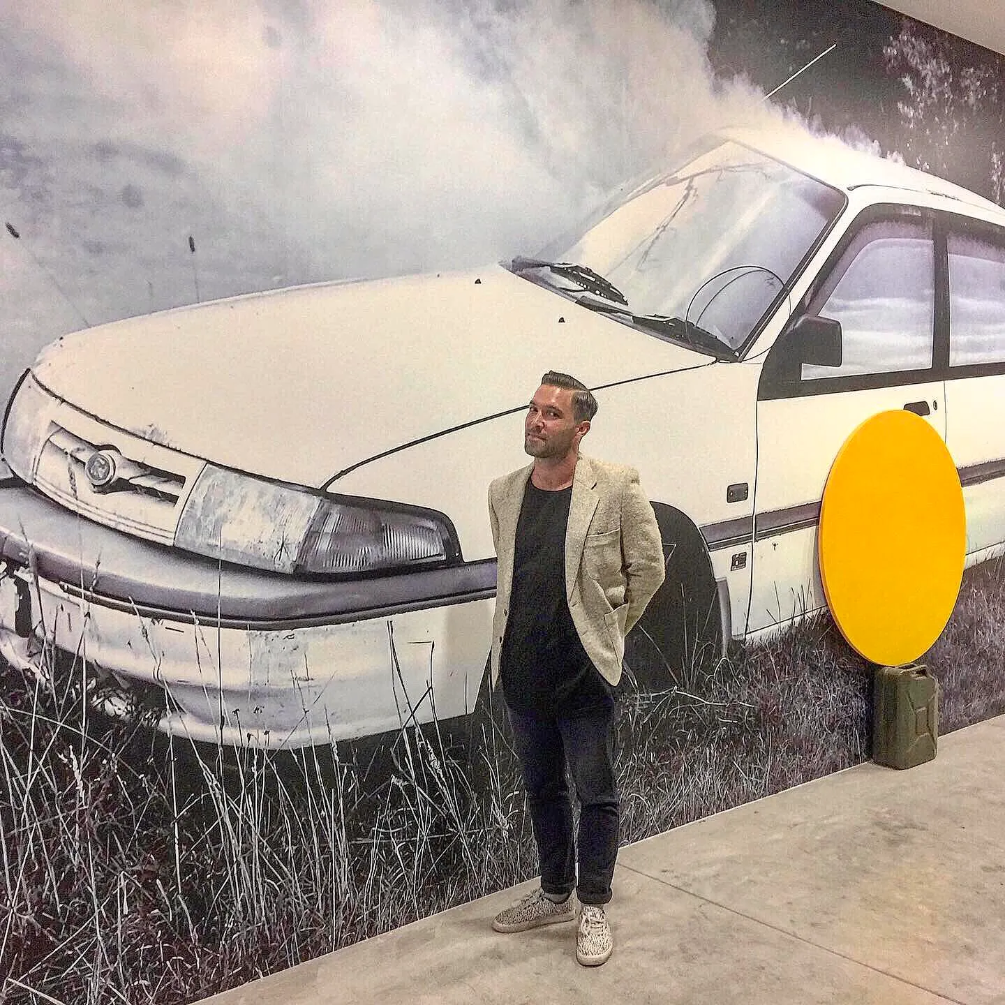 Artist dean Cross in from of his artwork on wallpaper at Yavuz Gallery