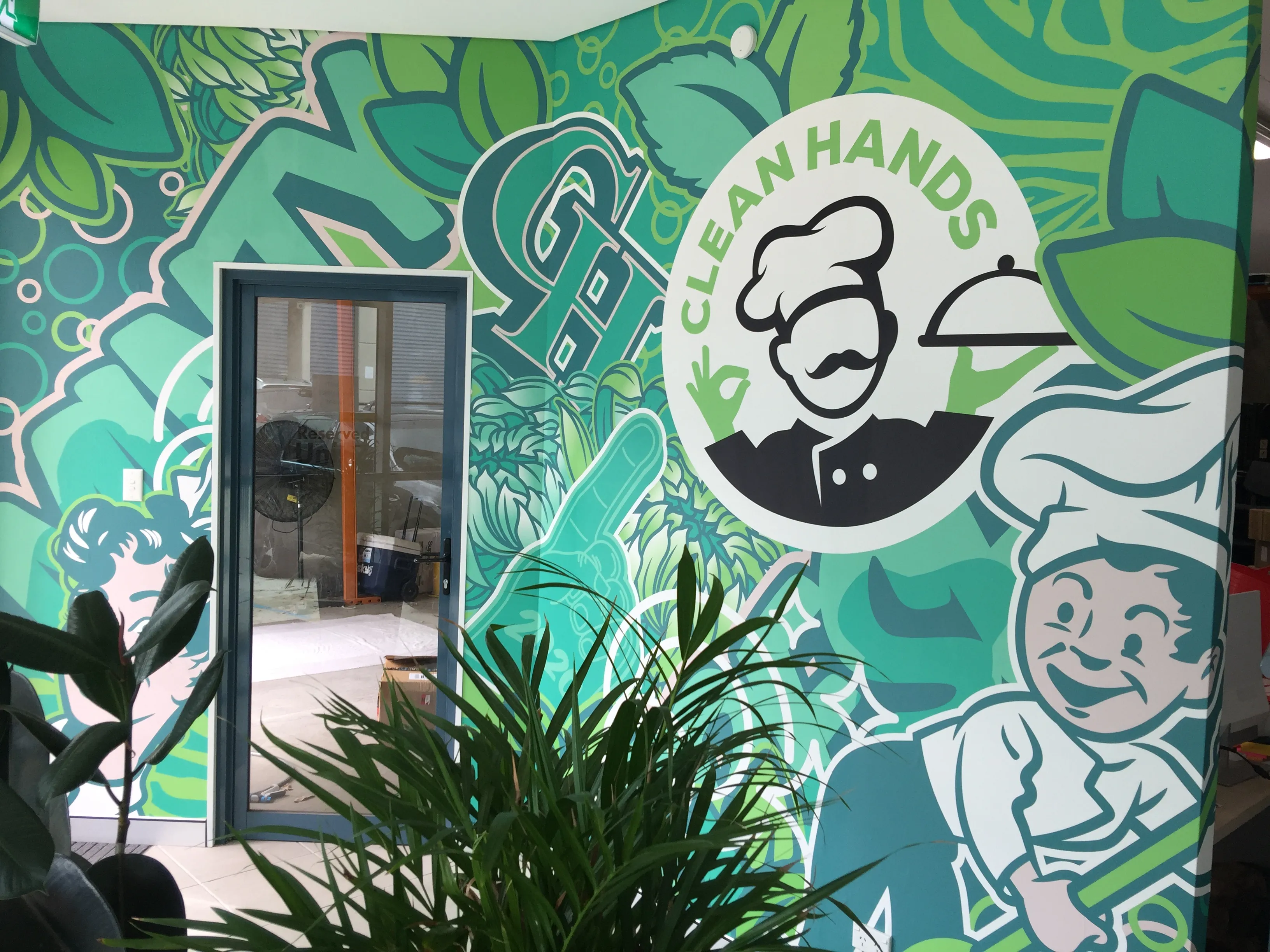Custom wallpaper mural in the entry area of a hospitality supply company with branded illustration