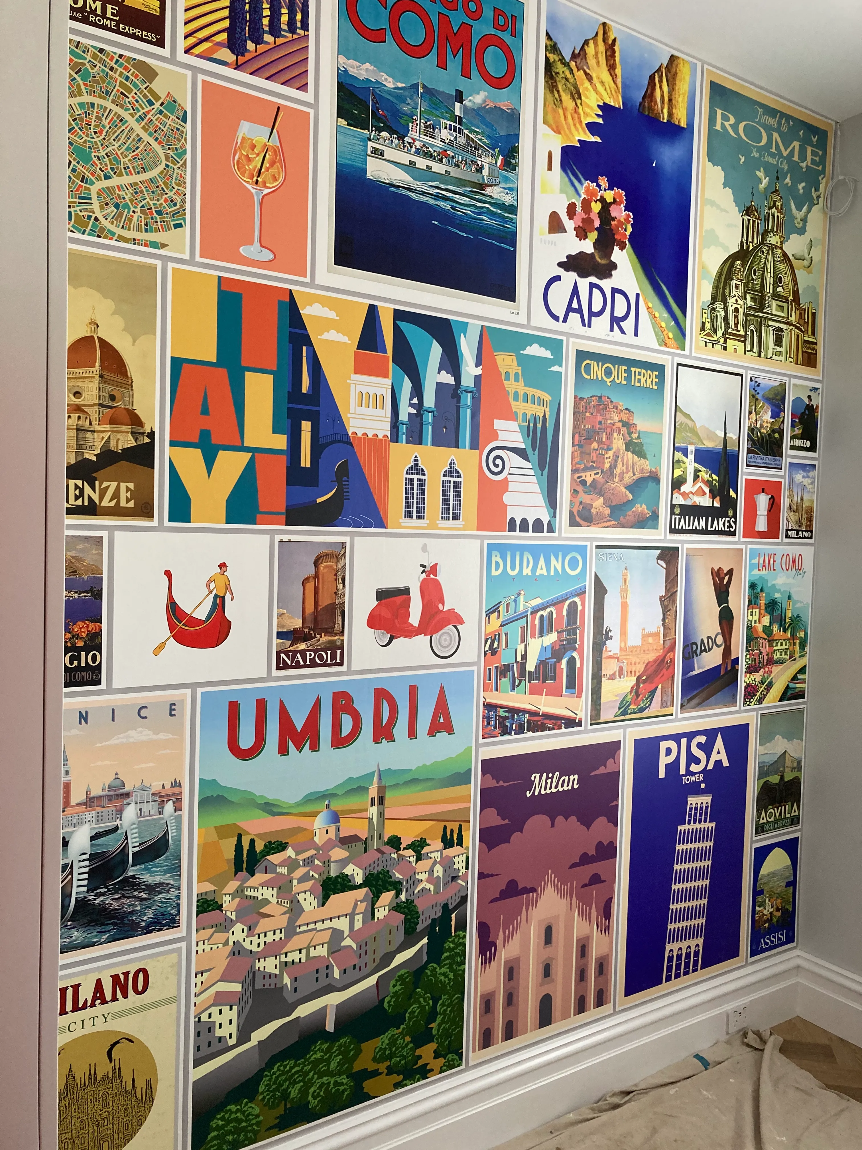 Collage of Italian vintage posters on custom printed wallpaper in kitche